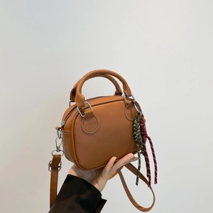 Retro caramel brown bowling bag with top handle and colorful woven charm details