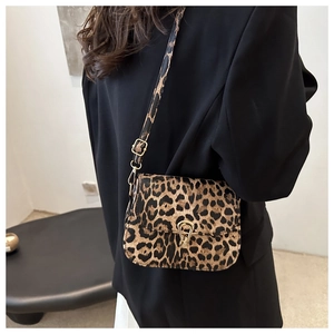 Detail of leopard print saddle bag with gold horseshoe buckle on black blazer