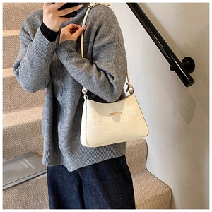 Detail of white PU leather underarm bag with lace texture and gold metal buckle