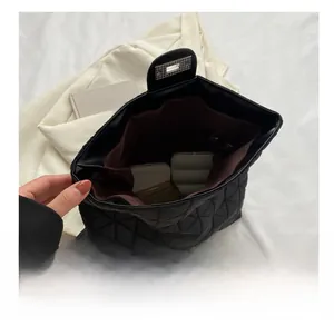 Interior view showing the large capacity of the black quilted tote bag with silver lock