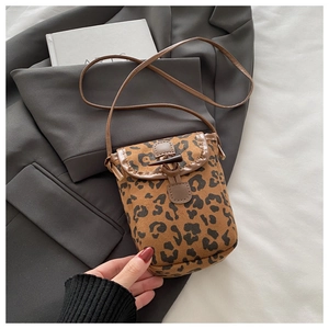 Detail view of leopard print faux suede bag with a classic horn buckle closure