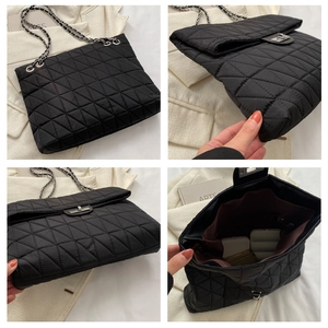 Detail view of black quilted chain bag with silver twist lock and spacious interior