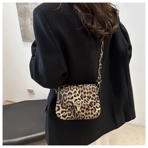 Detail of leopard print crossbody bag with gold buckle and textured faux fur finish