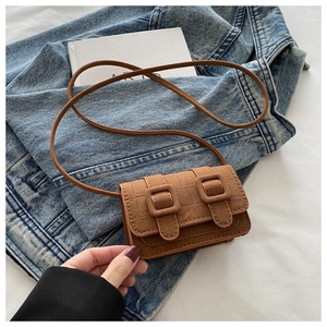 Detailed macro view of a brown vintage mini crossbody bag with crocodile texture and buckle