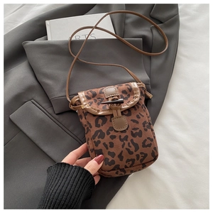 Detail of leopard print crossbody bag with vintage horn buckle and leather trim
