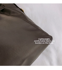 Close-up of brown nylon tote bag fabric texture with durable double stitching detail