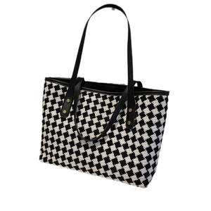 Large black and white checkered tote bag with leather straps and gold rivets