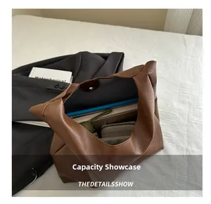 Capacity display of a brown lychee grain faux leather tote bag with laptop and essentials