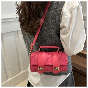 Detail of pink Boston bag showing delicate cherry blossom embossed texture and gold buckles