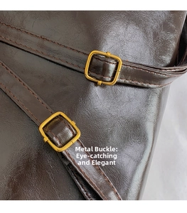 Close-up of vintage gold square buckles and dark brown oily leather texture on a tote bag