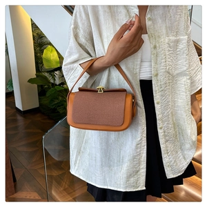 Détail du sac à main en cuir marron avec rabat tissé et boucle dorée rétro