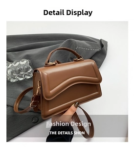 Detailansicht der braunen PU-Ledertasche mit gewellter Klappe und rundem Handgriff