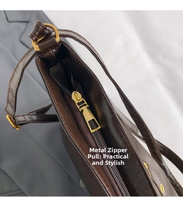 Close-up of golden zipper puller on deep brown glossy tote bag with leather texture
