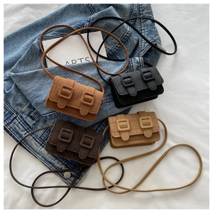 Close-up of four mini vintage crossbody bags in caramel, black, coffee, and beige colors