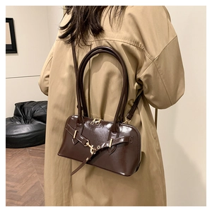 Detail of vintage brown leather bowling bag showing dual zippers and golden buckles