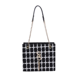 Classic black and white houndstooth tote bag with gold chain strap and metal logo