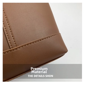 Detail aus karamellbraunem Leder mit Lychee-Maserung und präziser Doppelnaht an der Tasche