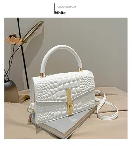Detail of white textured crossbody bag with gold metallic buckle and leather strap