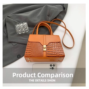 Detail view of orange crocodile texture handbag with gold clasp and phone for size reference