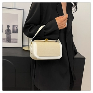 Détail du sac à main carré tendance avec fermoir doré et panneaux en tissu texturé