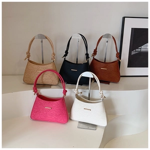 Detailed display of five colorful embossed leather shoulder bags on a minimalist rack