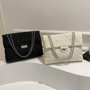 Quilted crossbody chain bag in black and white styles with metallic twist lock closure
