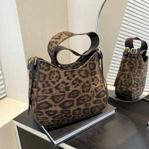 Chic leopard print hobo bag with wide black shoulder strap and gold hardware accents