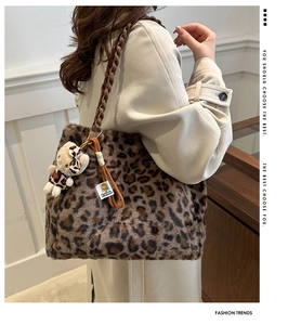 Detail of leopard print faux fur handbag featuring chunky brown acrylic chain and bear charm