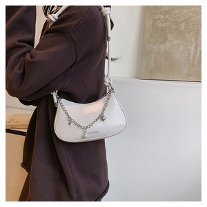 White crescent moon bag with silver charms and chain on a knit sweater outfit