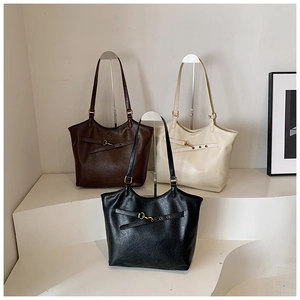 Detailed comparison of the black, brown, and cream large tote bags in leather texture