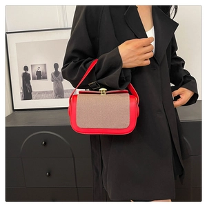 Détail d'un sac en cuir rouge avec rabat tissé et fermoir doré élégant