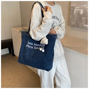Détail du sac cabas en denim avec broderie et breloque nuage blanc pour femmes