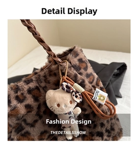 Detail of leopard print plush handbag featuring woven handles and kitty charm pendant