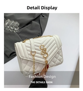Detail of white quilted crossbody bag with golden GS logo and fringe tassel chain