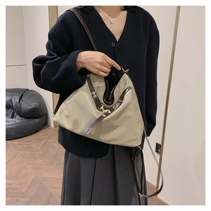 Detail of khaki nylon tote bag featuring geometric triangle folds and leather straps