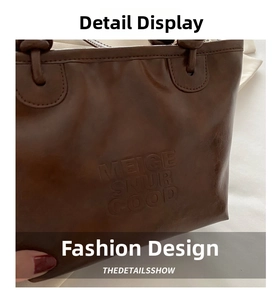 Detailed close-up of brown vintage leather bucket bag with MEIGE SNUR GOOD embossed lettering