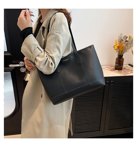 Detailaufnahme einer minimalistischen schwarzen Leder-Einkaufstasche mit Goldplakette