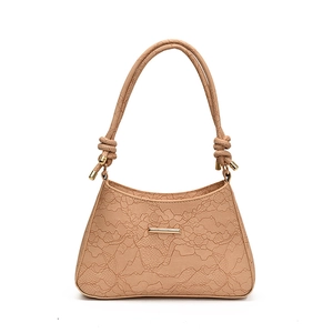 Beige lace-textured shoulder bag with gold hardware and knotted strap details