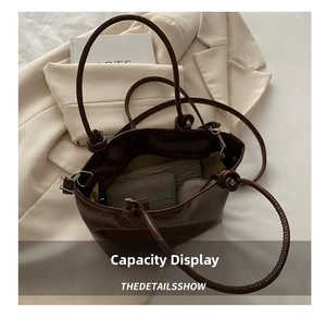 Detail of dark brown tote bag showing interior storage capacity and knot handle design