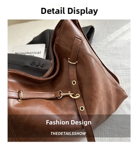 Detail of vintage brown PU leather bag with gold rings, hooks, and adjustable strap