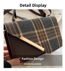 Detail of brown plaid fabric and leather shoulder bag with golden metal trim and D-ring hardware