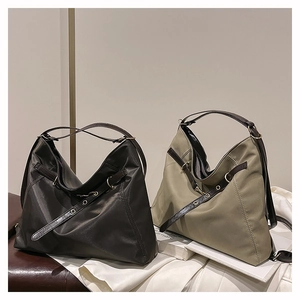 Detail view of large nylon tote bags in dark brown and khaki with leather straps