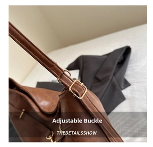 Detailed shot of brown leather tote strap with adjustable vintage gold buckle hardware