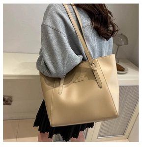 Dettaglio della tracolla regolabile e texture della pelle sulla borsa tote beige chiaro