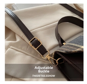 Detail of adjustable leather strap and golden buckle on a plaid crossbody bag