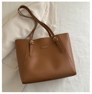 Dettaglio borsa tote in ecopelle marrone caramello con fibbia dorata e tracolla
