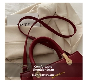 Detail of red leather handbag with gold hardware and stylish shoulder strap by a blazer