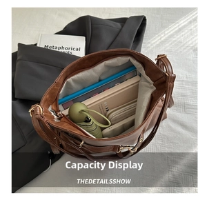 Spacious interior of brown leather tote bag showing capacity for books and umbrella