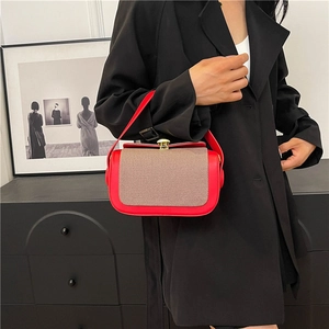 Sac à main chic en cuir rouge avec empiècement en sergé et fermoir doré sur modèle