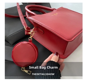 Detail of red square handbag with gold lettering and a matching round coin purse charm